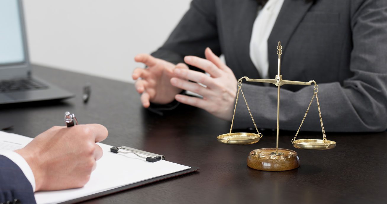 Close-up-of-hands-over-legal-documents-during-consultation