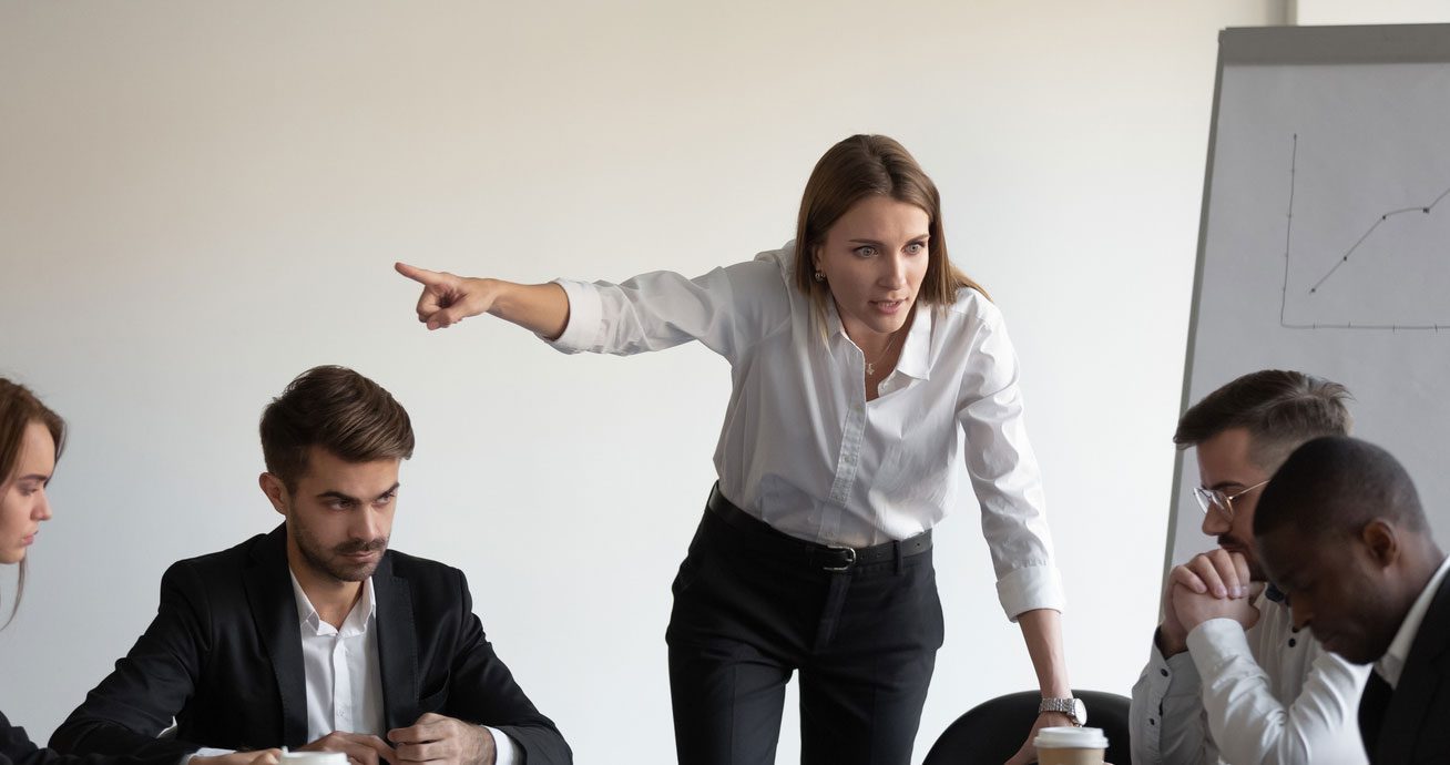 Female-boss-gesturing-while-speaking-to-male-employee-in-office
