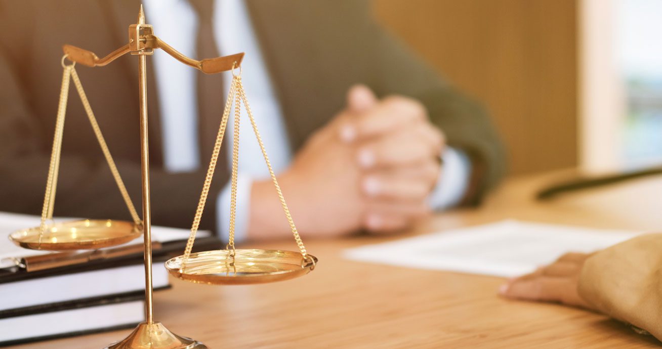Female-lawyer-shaking-hands-with-client-across-desk-during-meeting