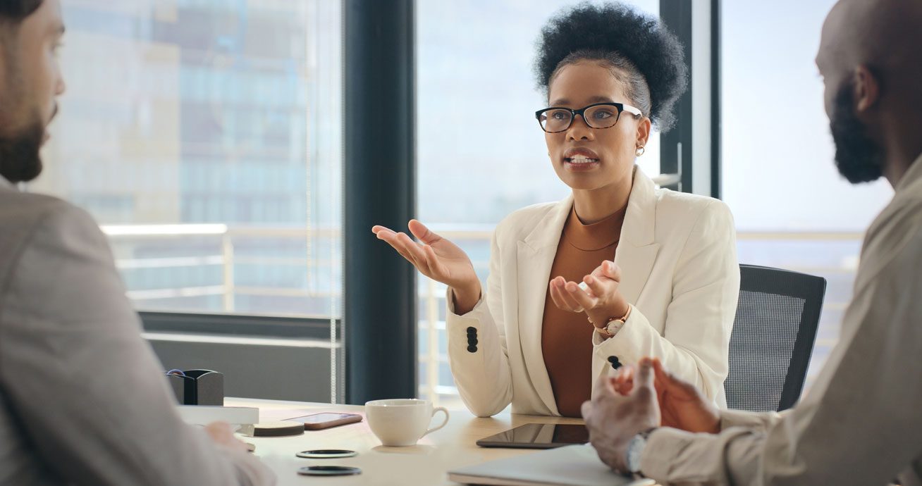 Two-businesspeople-discussing-documents-during-meeting-at-desk