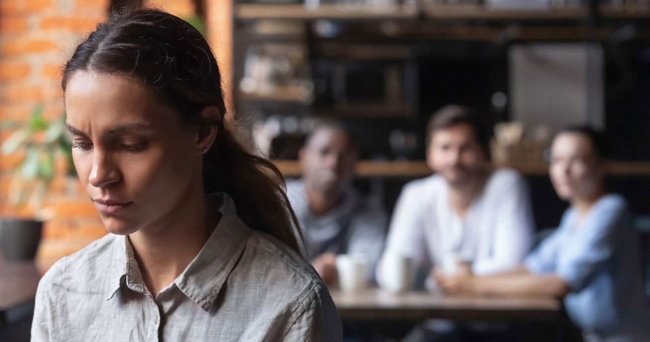Woman-sitting-alone-at-table-looking-down