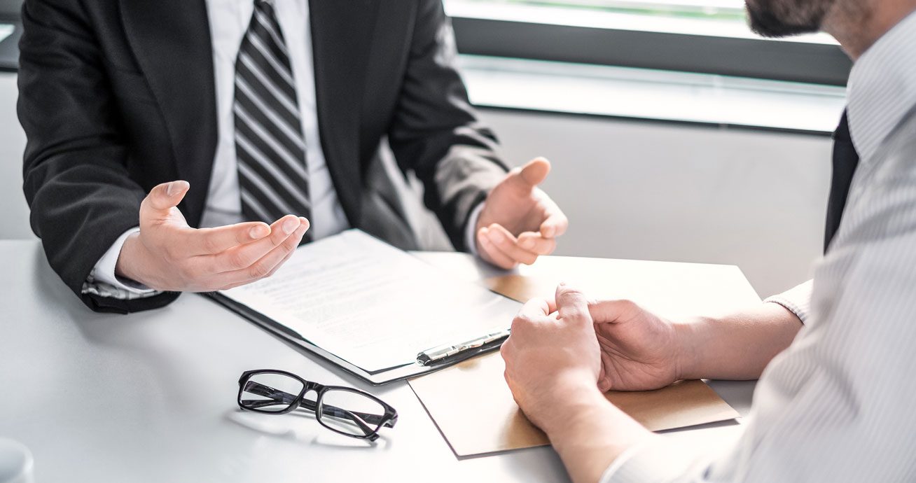 Businesspeople-reviewing-and-signing-contract-documents-at-table