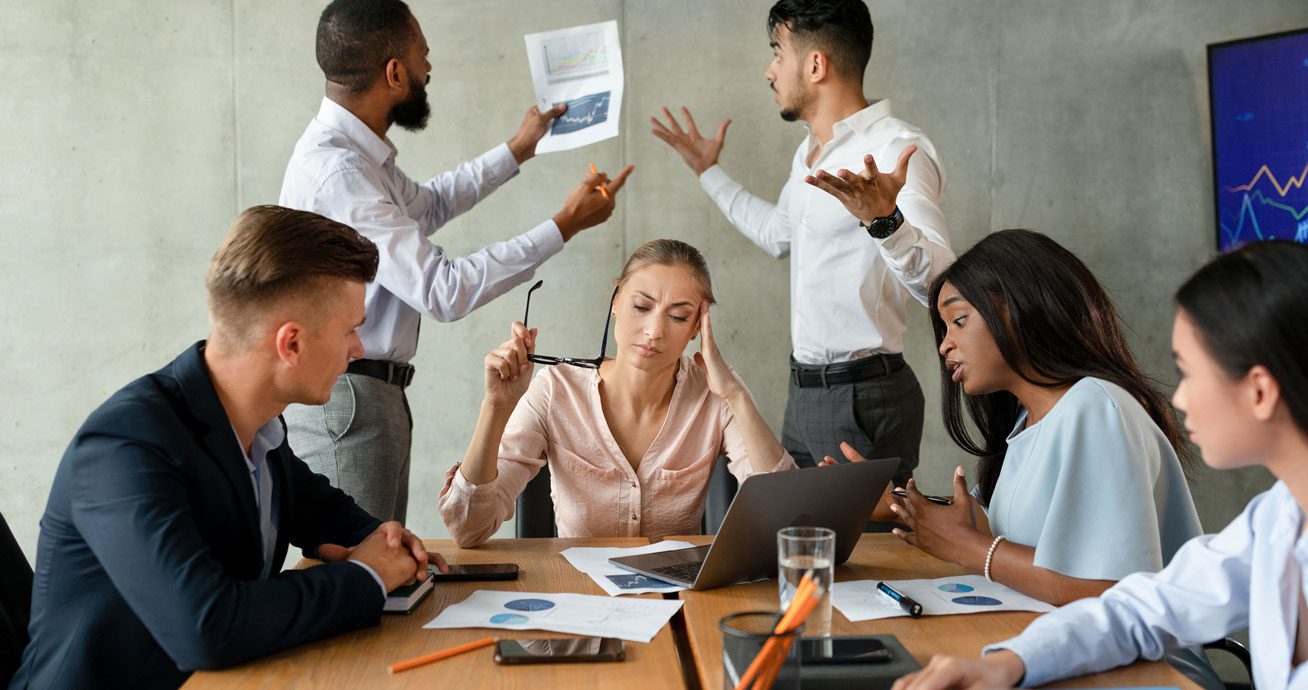Group-of-coworkers-arguing-around-table-during-meeting