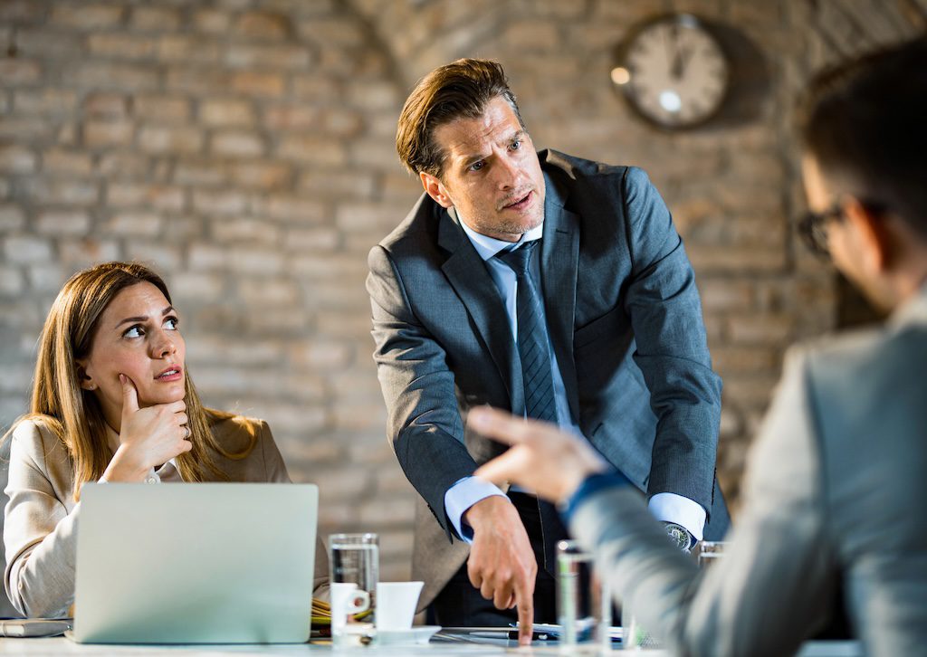 man-standing-and-speaking-during-a-team-meeting