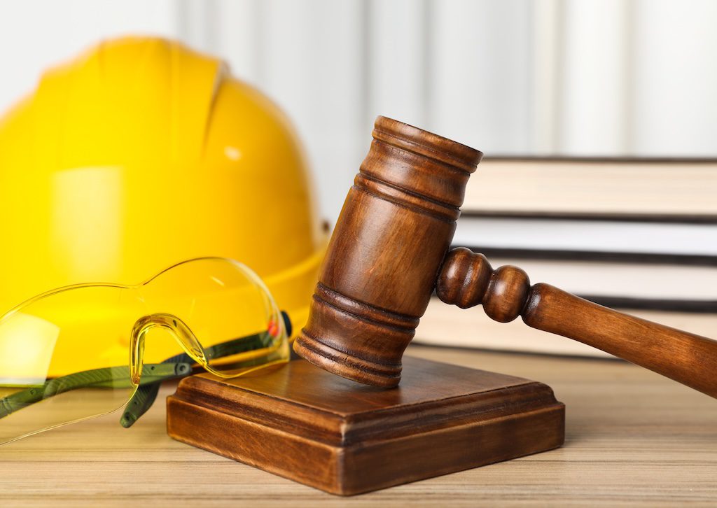 yellow-hard-hat-and-gavel-on-a-desk-beside-law-books