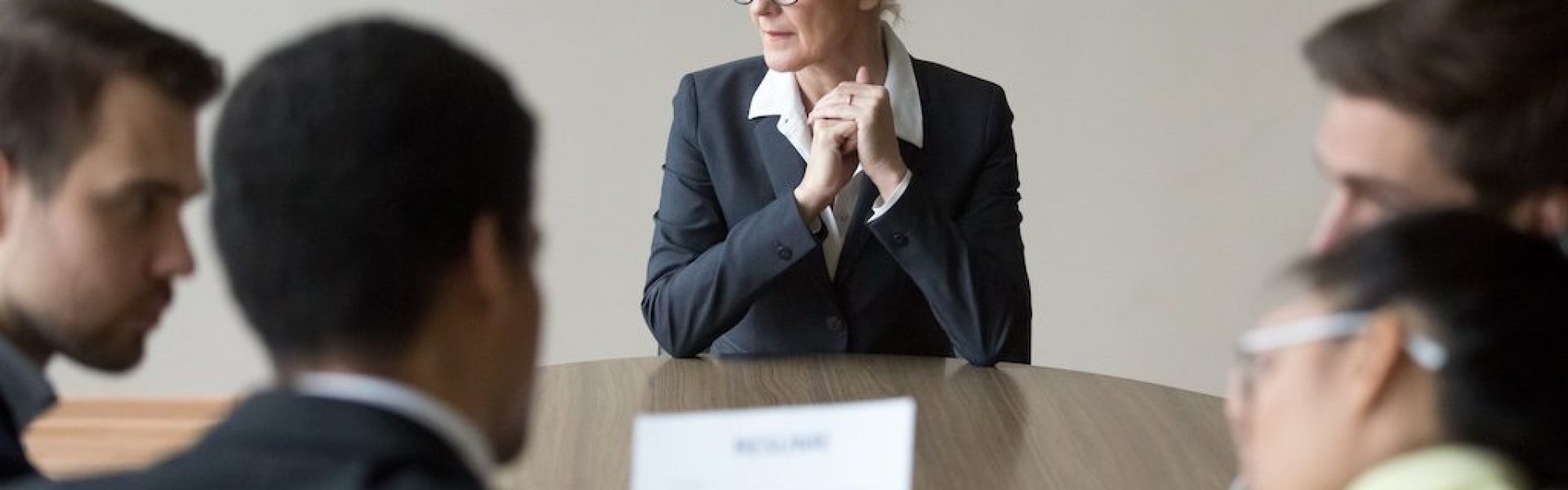 group-meeting-around-a-table-with-one-woman-standing-at-the-front
