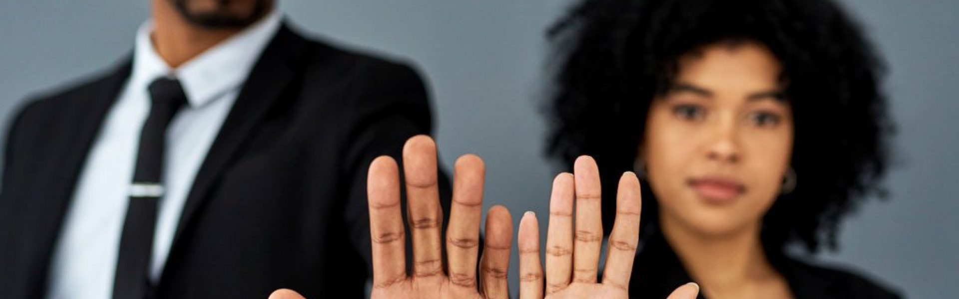 man-and-woman-holding-up-palms-reading-equal-pay