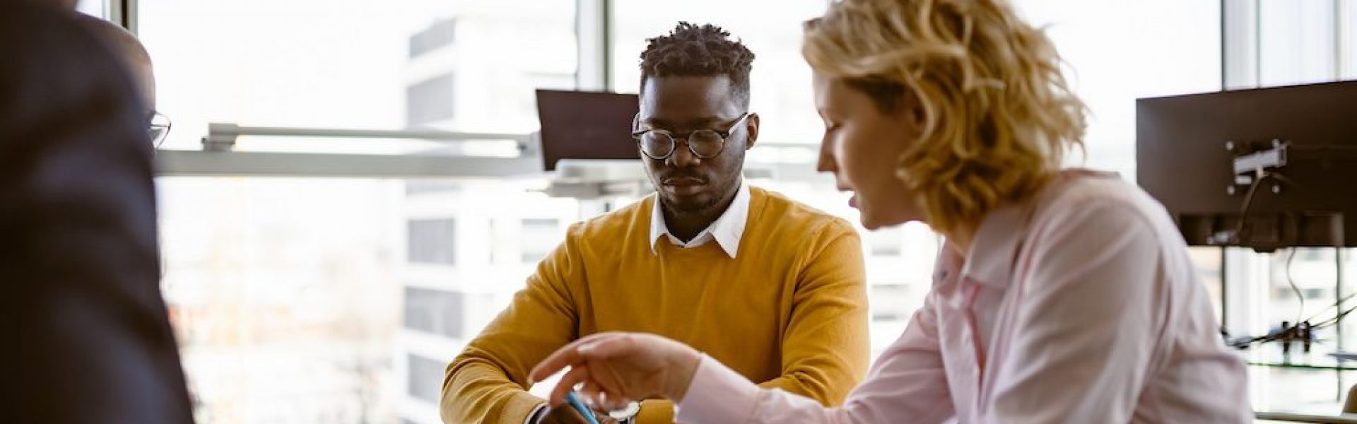 three-people-meeting-at-a-table-in-a-bright-office