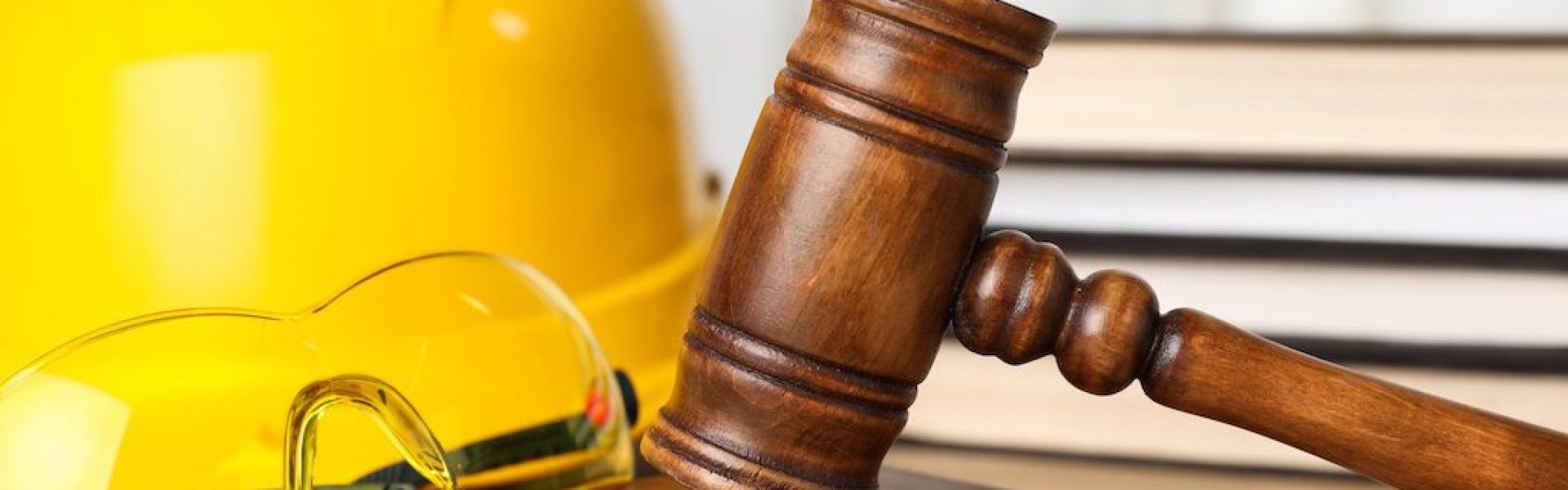 yellow-hard-hat-and-gavel-on-a-desk-beside-law-books